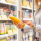 Woman reading ingredients information on juice bottle