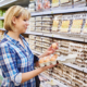 Woman chooses packing eggs in supermarket