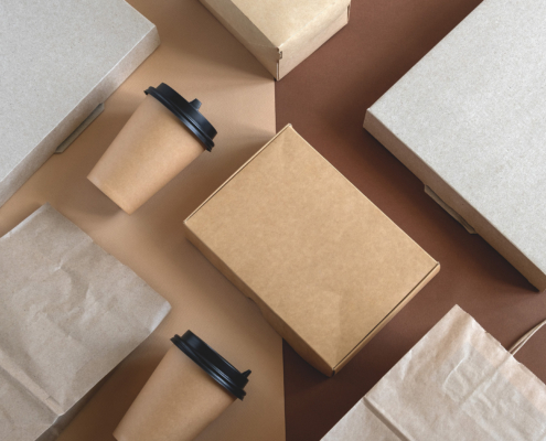 top view flat lay disposable blank delivery food packaging on a beige and brown background
